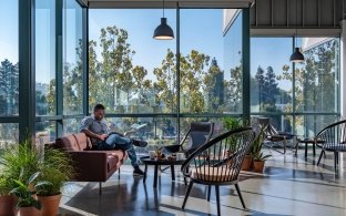A person sitting in a lounge area with lots of sunlight.
